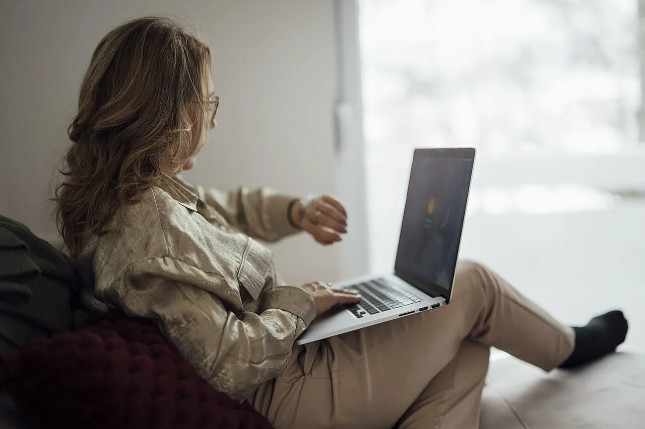 Adult woman checking the time while using a laptop
