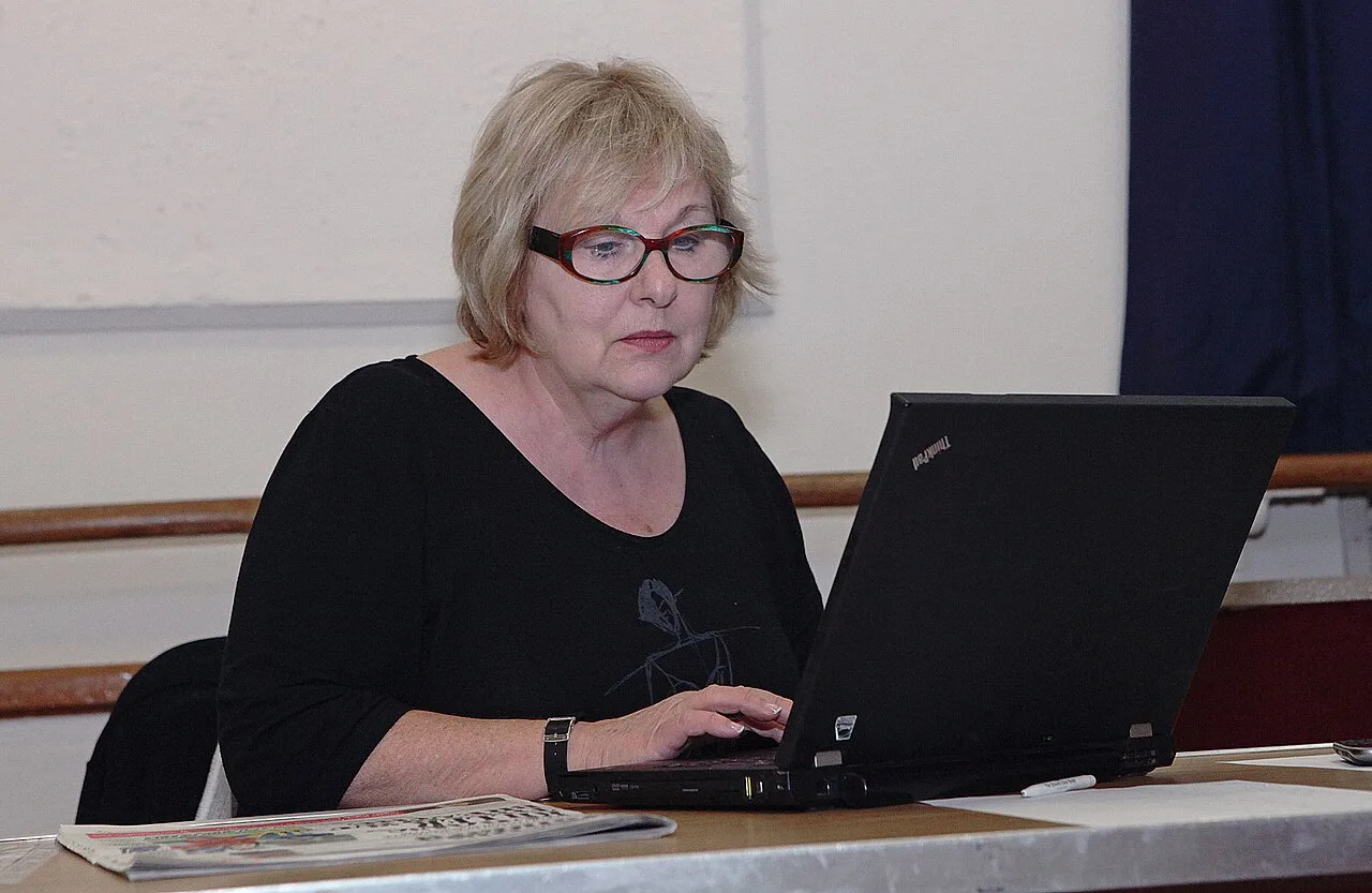 Adult woman using a laptop while comparing online choices