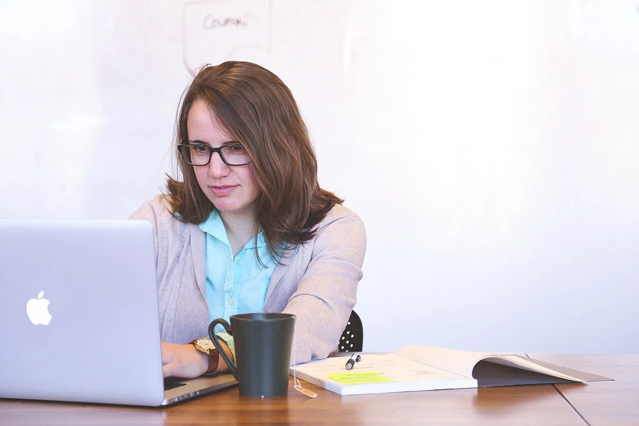 Adult woman working at a laptop in a bright home office